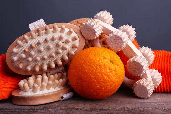 Brosse à rouleaux, serviette, brosses orange et ovale sur table en bois sur fond gris foncé — Photo