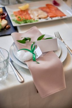 Masada bej peçete ve çatal bıçaklı tabak seti, kopyalama alanı. Düğün resepsiyonunda. Restoranda düğün yemeği için servis edilen masa.