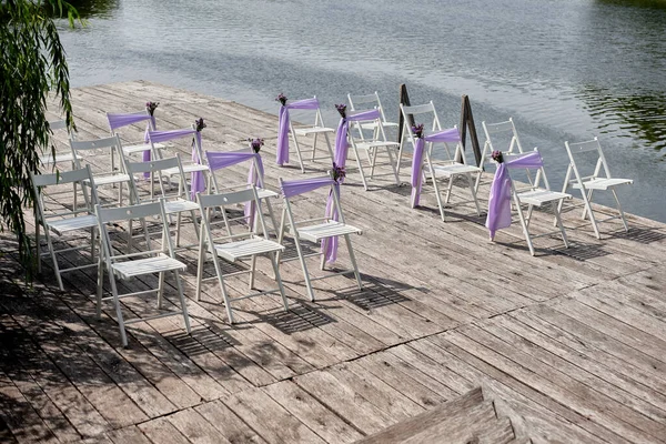 Білі Весільні Стільці Свіжими Квітами Фіолетовою Тканиною Кожного Боку Арки — стокове фото