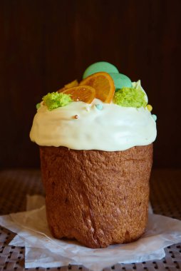 Kuru turuncu dilimlerle süslenmiş jöleli paskalya pastası ve koyu arkaplanda şekerler, kopyalama alanı. Mutlu Paskalyalar. Kulich 