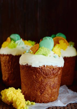 Kuru turuncu dilimlerle süslenmiş jöleli paskalya pastası ve koyu arkaplanda şekerler, kopyalama alanı. Mutlu Paskalyalar. Kulich 