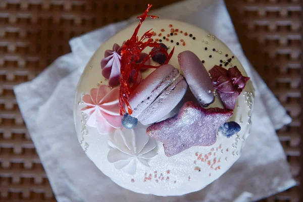Beyaz desenli arka planda çiçeklerle süslenmiş jöleli paskalya pastası. Ve beyaz mermer arka planda mini çikolata yumurtaları. Mutlu Paskalyalar. Uzayı kopyala Kulich. Üst manzara, düz uzanma