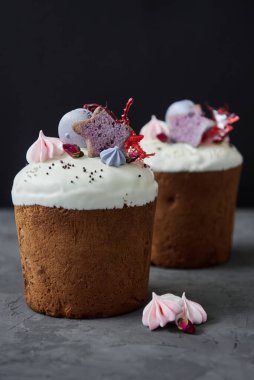 Koyu arkaplanda kremalı paskalya pastası, badem kurabiyesi ve şekerle süslenmiş, kopyalama alanı. Mutlu Paskalyalar. Kulich 