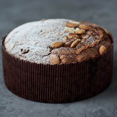 Koyu arkaplanda şeker tozuyla süslenmiş İtalyan Paskalya pastası, kopyalama alanı. Mutlu Paskalyalar. Panettone. Paskalya güvercini ekmeği Colomba