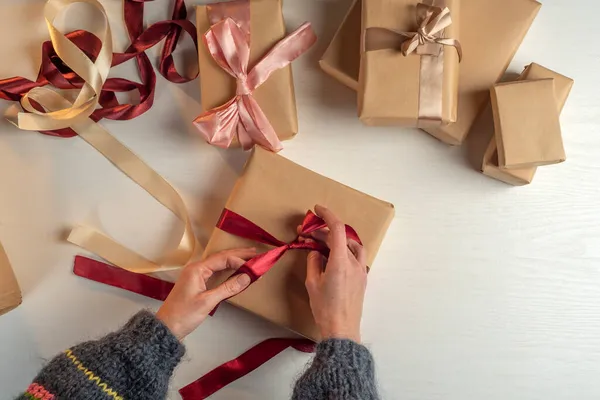 Gift wrapping in craft paper. Packaging process. Preparation.