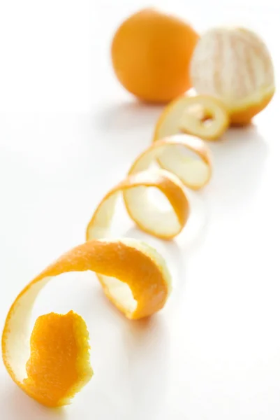Naranja posado sobre una cáscara de naranja sobre fondo blanco — Foto de Stock