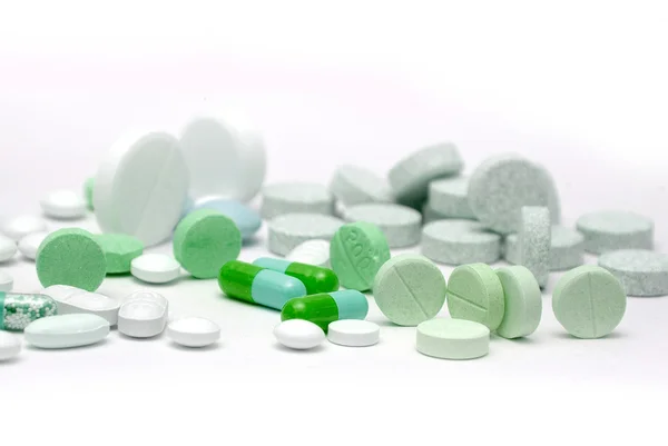 Tablets and capsules on white background — Stock Photo, Image