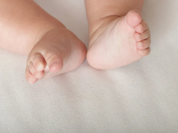 Pied bébé entre les mains de la mère — Photo