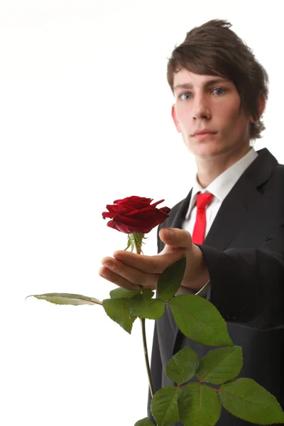 Ung man presentera en blomma röd ros isolerade — Stockfoto