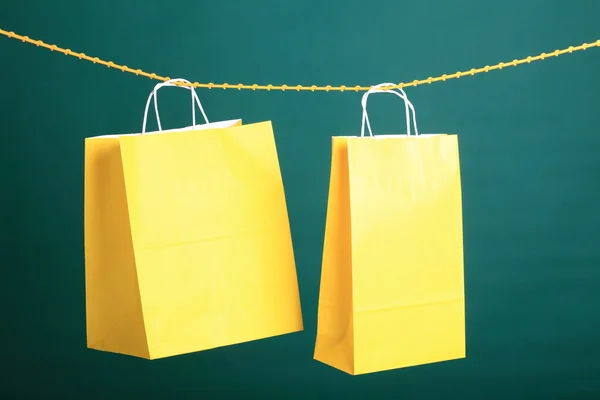 Shopping yellow gift bags on green background — Stock Photo, Image