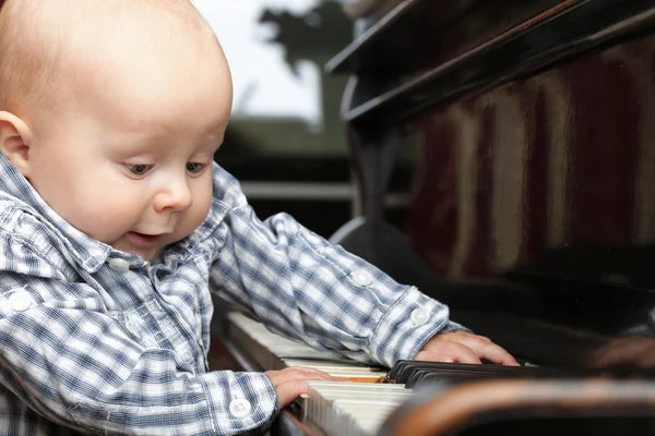 Vackra lilla pojke spelar piano — Stockfoto