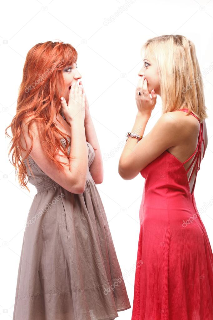 society gossip - two happy young girlfriends talking white backg