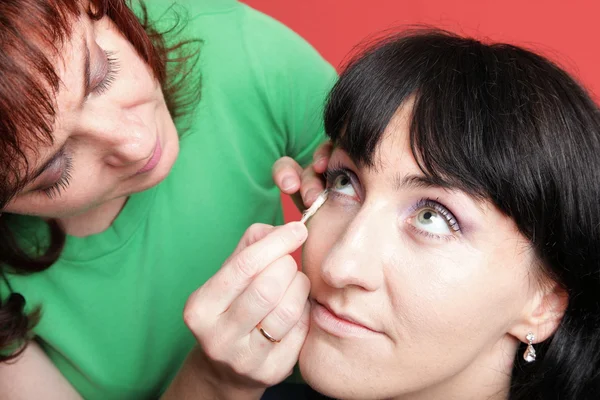 Mujer pinta la cara con maquillaje — Foto de Stock