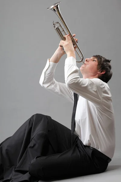 Porträt eines jungen Mannes, der seine Trompete spielt — Stockfoto