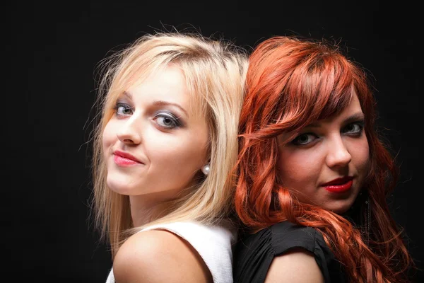 Two happy young girlfriends black background — Stock Photo, Image