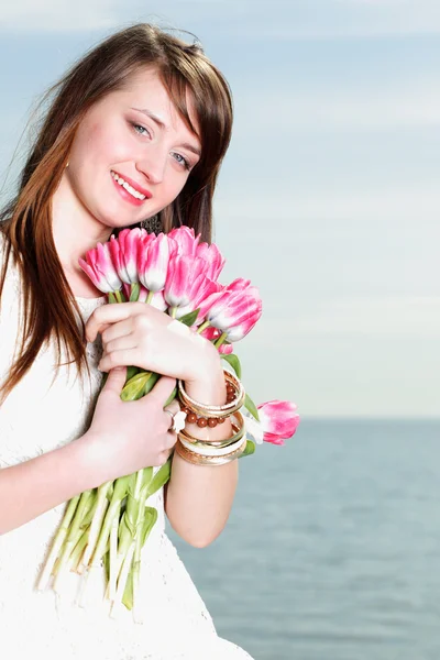 Улыбающаяся женщина с букетом цветов — стоковое фото