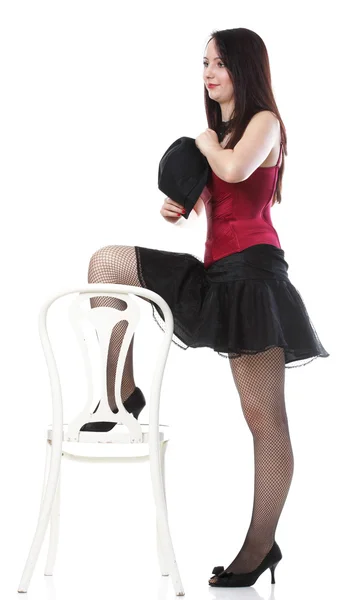 Showgirl woman dance in red corset chair white isolated — Stock Photo, Image