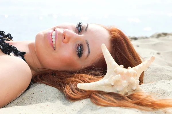 Het mooie meisje ligt op een Zeekust met schelpen natuur vakantie — Stockfoto