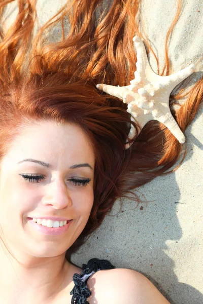 The beautiful girl lies on sea coast with shells nature vacation — Stock Photo, Image