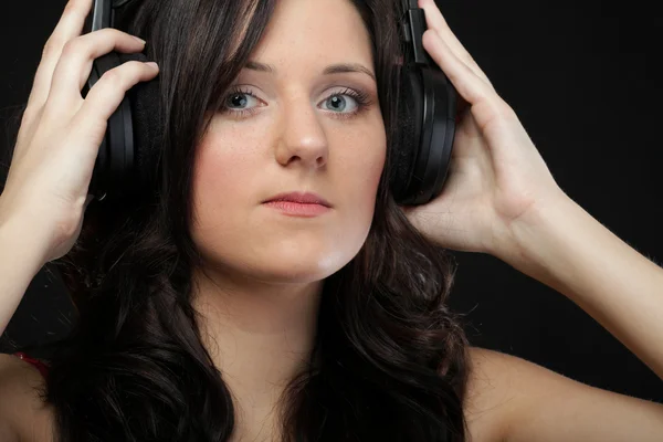 Mujer joven escuchando música en auriculares — Foto de Stock