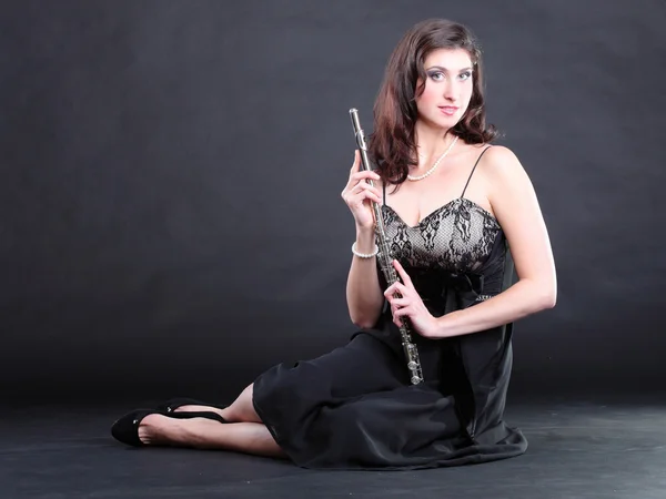 Menina e flauta em um fundo preto — Fotografia de Stock