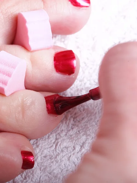 Pés femininos unhas polidas vermelhas — Fotografia de Stock