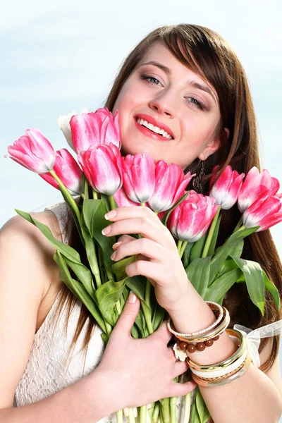 Smiling woman with bunch of flowers