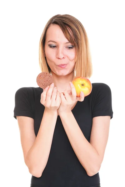 Young beautiful female choose from sweet cake and red apple — Stock Photo, Image