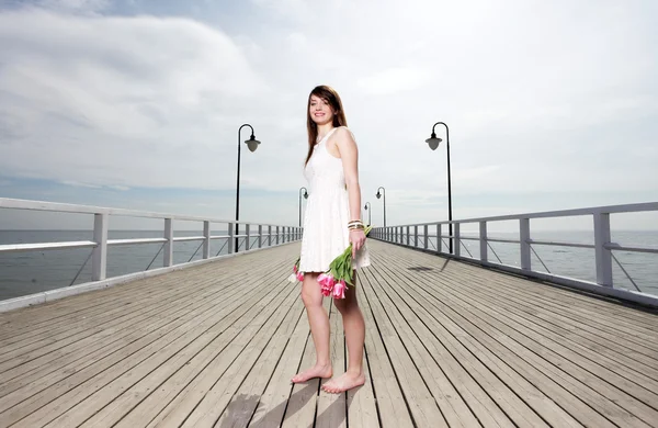 花の海の束を持つ女性の笑みを浮かべてください。 — ストック写真
