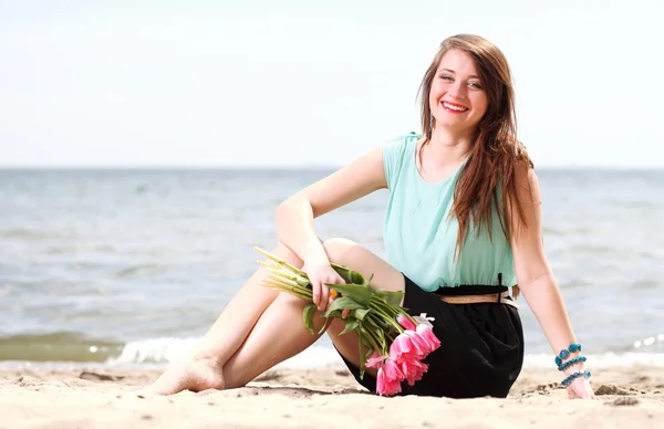 Молодая красивая женщина портрет на пляже букет цветов — стоковое фото
