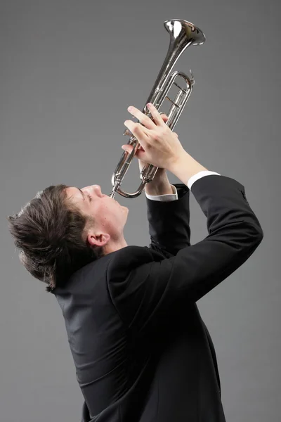 Portréja egy fiatal ember, játszik a trombita — Stock Fotó