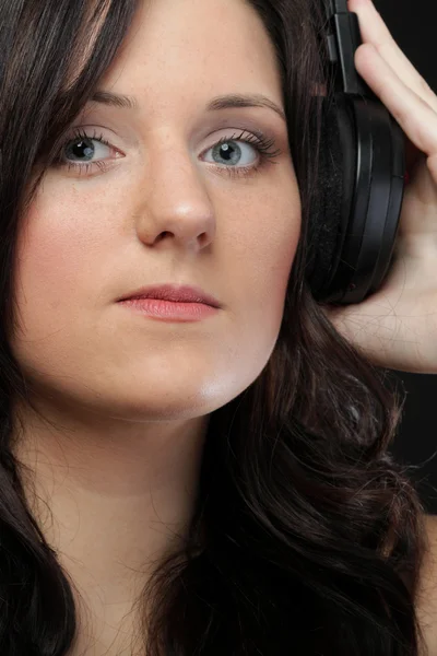 Mujer joven escuchando música en auriculares — Foto de Stock