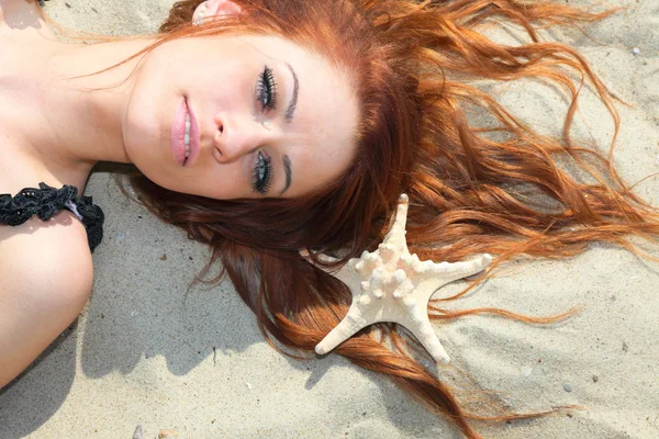 Das schöne Mädchen liegt an der Küste mit Muscheln Natururlaub — Stockfoto