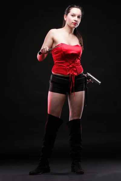 Сексуальная молодая женщина - пистолет на черном фоне — стоковое фото