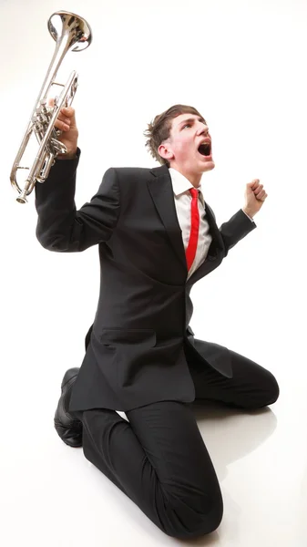 Genç adam neşe, glee ve onun trompet — Stok fotoğraf