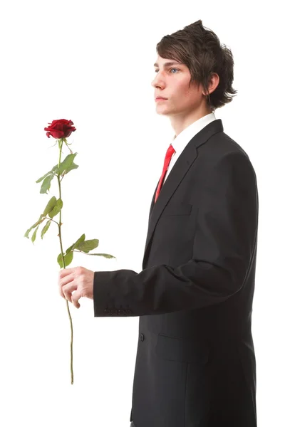 Jovem apresentando uma flor vermelha rosa isolada — Fotografia de Stock