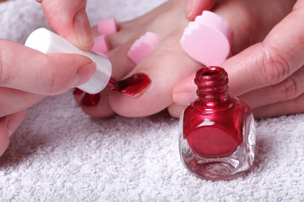 Vrouwelijke voeten rood gepolijst nagels — Stockfoto