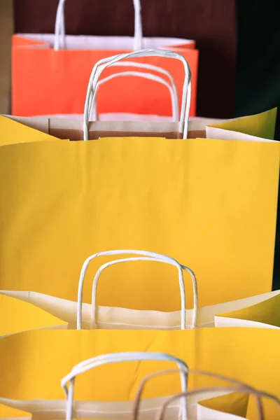 Compras bolsas de regalo amarillas sobre fondo verde —  Fotos de Stock