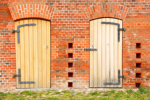 Закрытая деревянная дверь в кирпичной стене — стоковое фото