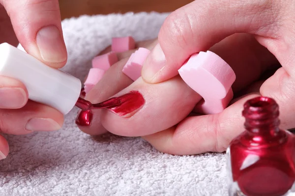 Vrouwelijke voeten rood gepolijst nagels — Stockfoto