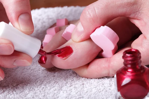 Pés femininos unhas polidas vermelhas — Fotografia de Stock