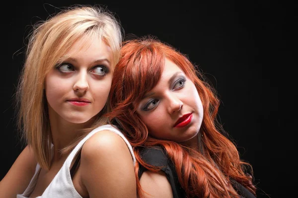 Two happy young girlfriends black background — Stock fotografie