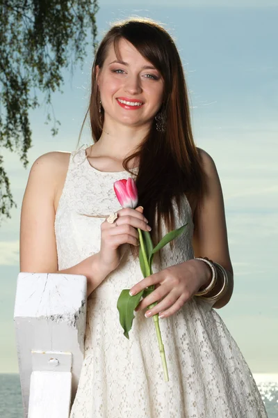 Leende kvinna med tulpan blommor — Stockfoto