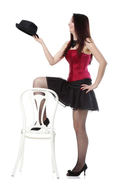 Showgirl woman dance in red corset chair white isolated — Stock Photo, Image