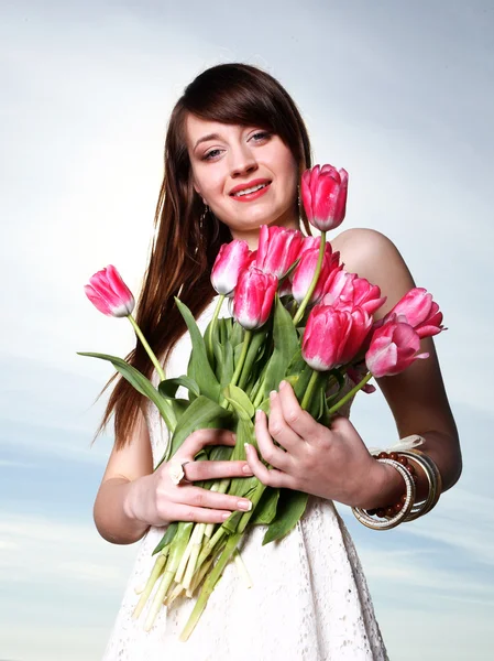 Leende kvinna med massa blommor — Stockfoto