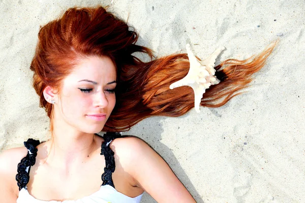 Das schöne Mädchen liegt an der Küste mit Muscheln Natururlaub — Stockfoto