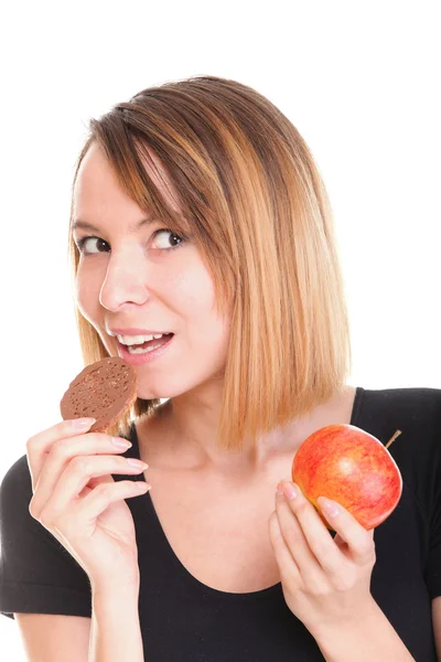 Jonge mooie vrouw kiezen uit zoete taart en rode appel — Stockfoto