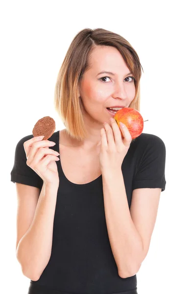 Young beautiful female choose from sweet cake and red apple — Stock Photo, Image