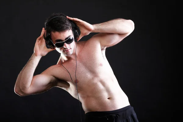 Yakışıklı bir adam üzerinde kulaklık müzik dinlemek — Stok fotoğraf