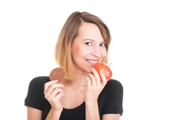 Young beautiful female choose from sweet cake and red apple — Stock Photo, Image